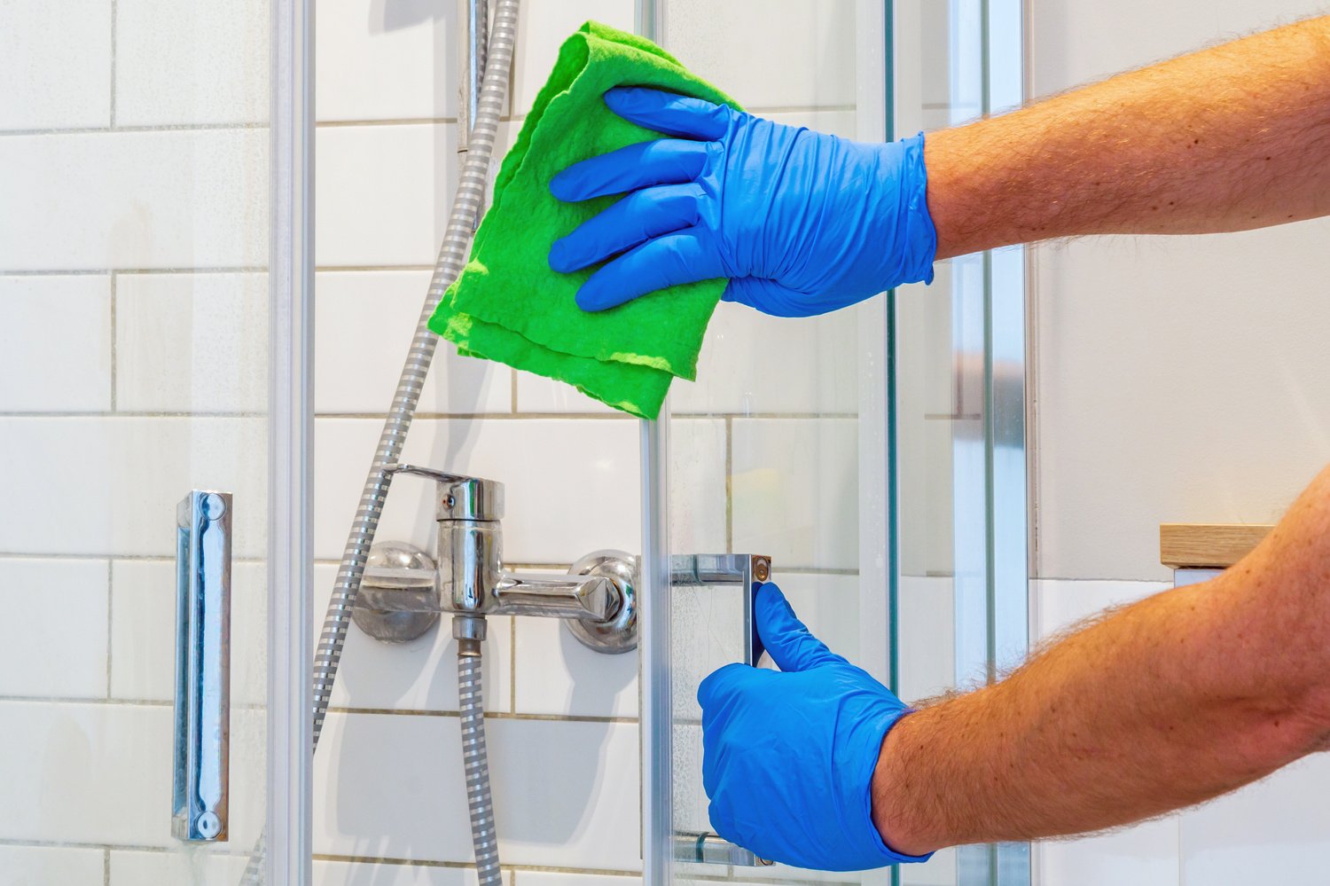 The cleaner washes  door in bathroom with detergents. Bathroom cleaning idea